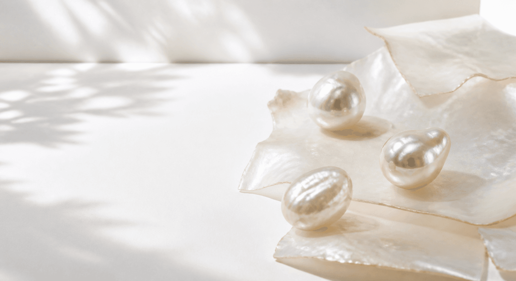 Pearl jewellery arranged on soft ivory fabric