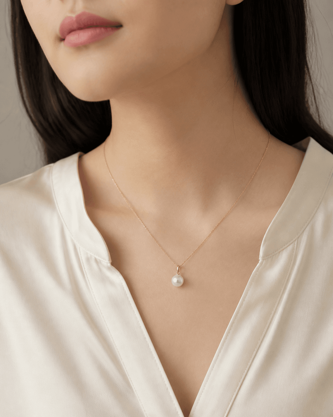 Pearl pendant worn with an ivory silk blouse